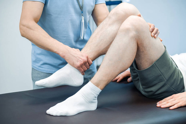 Αποκατάσταση ποδιών. Αρσενικός φυσιοθεραπευτής που εργάζεται με πόδια ασθενών - Φωτογραφία, εικόνα