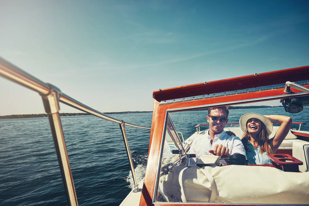 Neem je boot en reis de wereld rond. een liefdevol jong koppel zeilen op de open zee in hun jacht - Foto, afbeelding