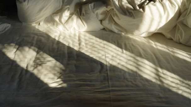The morning sunlight projecting the window shadow on the bed - Фото, изображение