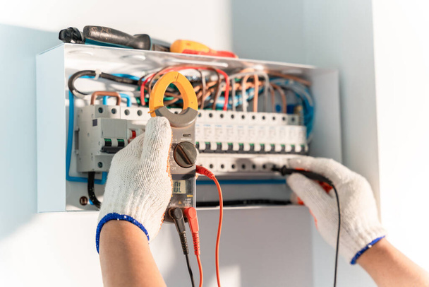 Ręka inżyniera elektryka testuje instalacje elektryczne i przewody w systemie ochrony przekaźników. Rozdzielnice średniego napięcia - Zdjęcie, obraz