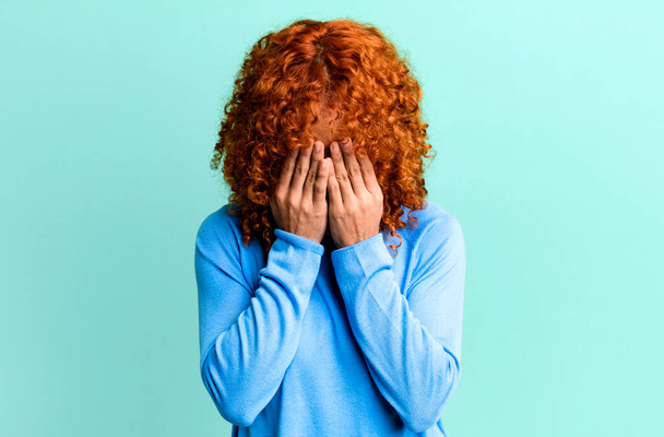 redhair pretty woman feeling sad, frustrated, nervous and depressed, covering face with both hands, crying - Foto, imagen