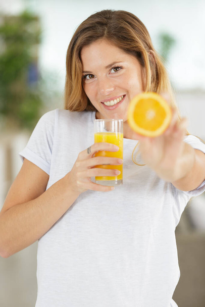 picture of woman holding orange slice and juice - Photo, Image