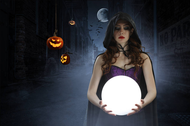 Gyönyörű fiatal nő boszorkány kalapban és jelmezben. Halloween művészet design. Vegyes média - Fotó, kép
