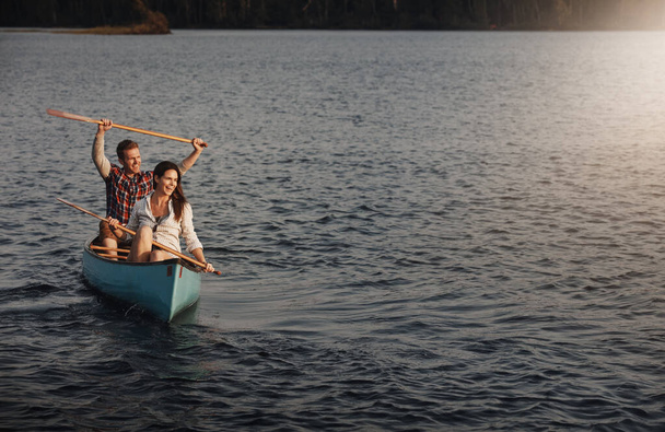 Succès d'aviron. un jeune couple ramant un bateau sur le lac - Photo, image