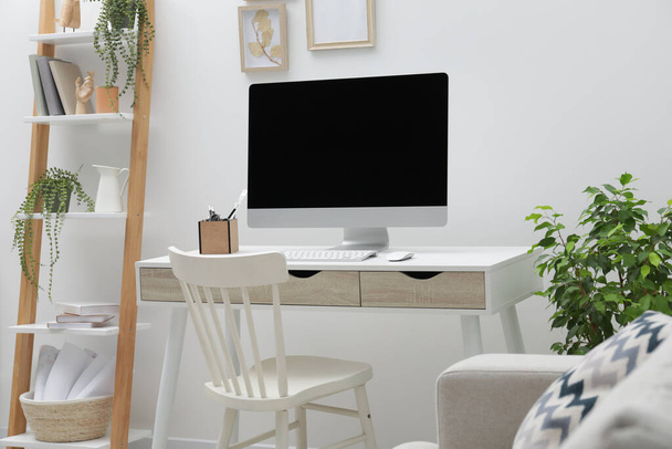 Spacious workspace with desk, chair, computer and potted plants at home - Valokuva, kuva