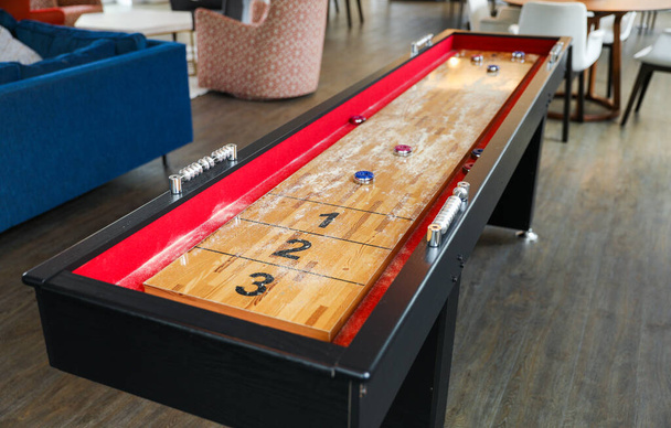 Shuffleboard is a game of precision and strategy, where players slide weighted discs down a narrow court to reach scoring areas. The sport represents the pursuit of accuracy and patience - 写真・画像