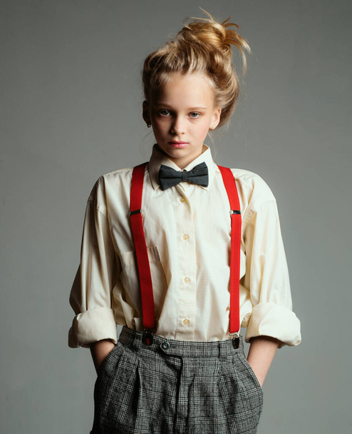 Funky style. suspender and bow tie. old fashioned child. vintage english style. retro fashion model. vintage charleston party. jazz step fashion. teen girl in retro male suit. Cool and trendy. - Foto, Imagen
