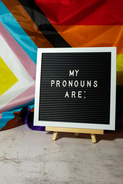 MIJN PRONOUNS ZIJN tekst Neo voornaamwoorden concept op Rainbow vlag achtergrond geslacht voornaamwoorden. Niet-binaire mensen rechten transgenders. Lgbtq steun van de gemeenschap veronderstel mijn geslacht, respect voornaamwoorden tolerantie gelijk - Foto, afbeelding