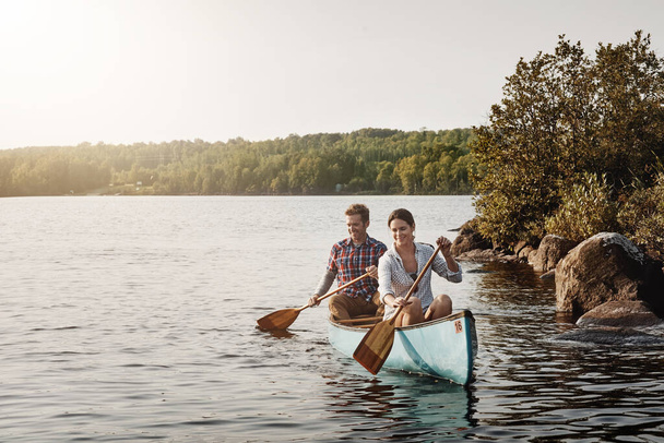 La vida es un paseo en canoa relajante. una joven pareja que va a dar un paseo en canoa por el lago - Foto, Imagen