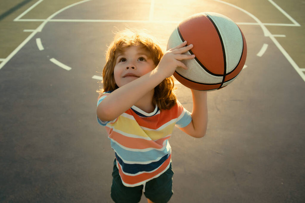 Happy little boy kid playing basketball on playground. Sport for kids - Zdjęcie, obraz
