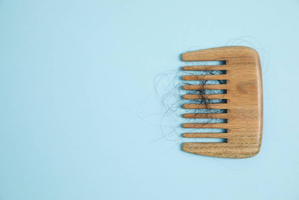 Wooden comb with lost hair on light blue background, top view. Space for text - Fotografie, Obrázek