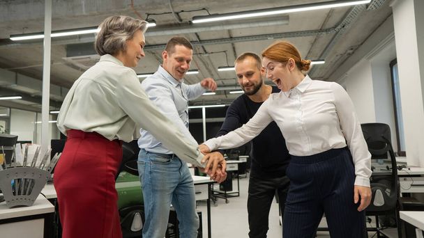 Four colleagues give the low five in the office - Fotografie, Obrázek