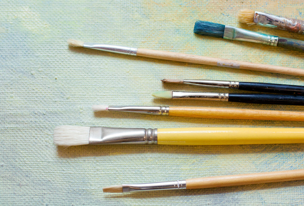 Paint brushes on an oil canvas - Photo, Image