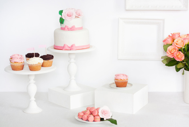 Κέικ διακοσμημένο με τριαντάφυλλα και τόξα, με cupcakes και macarons - Φωτογραφία, εικόνα