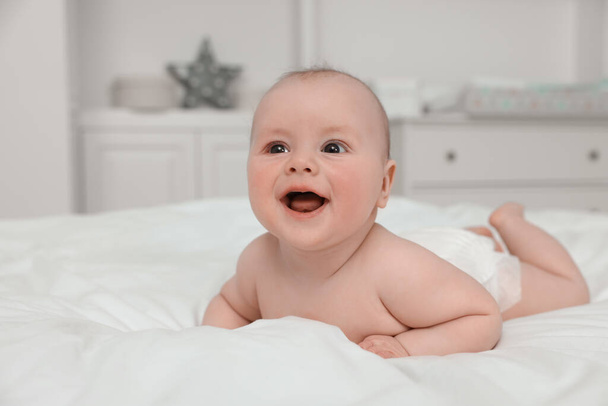 Cute baby lying on white bed at home - Foto, afbeelding