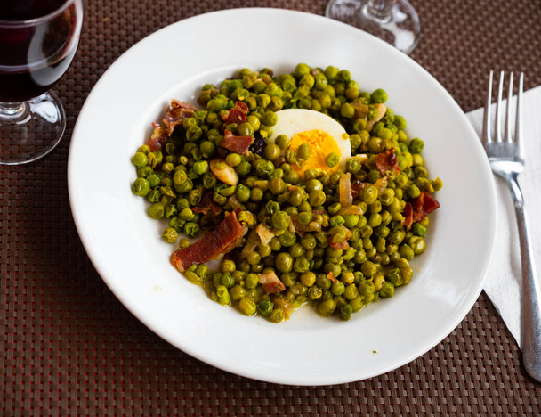 Just cooked green peas with ham and egg served on plate and ready-to-eat. - Photo, Image