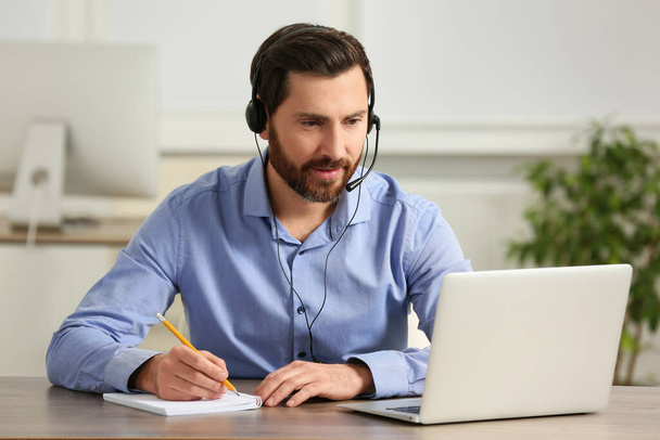 Hotline operator with headset working in office - Foto, imagen