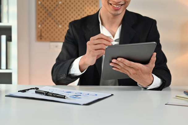 Business manager di marketing maschile seduto in ufficio moderno e utilizzando tablet digitale. Concetto di tecnologie aziendali. - Foto, immagini