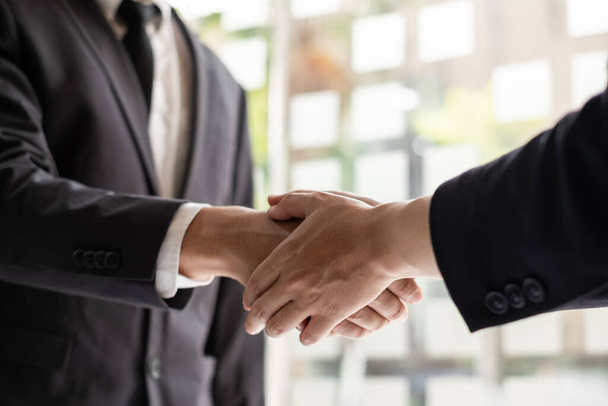 Deux hommes d'affaires se serrent la main dans la salle de bureau. félicitations, salutation et concept de négociation. - Photo, image