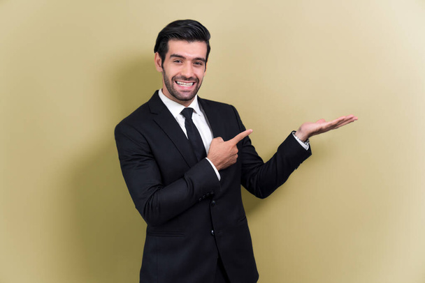 Fiducioso uomo d'affari in giacca e cravatta che punta il dito e tiene la mano gesto per indicare la promozione o la pubblicità su spazio vuoto con espressione facciale eccitato su sfondo isolato. Irritante - Foto, immagini