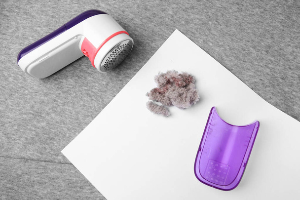 Modern fabric shaver and lint on light grey cloth, flat lay - Foto, imagen