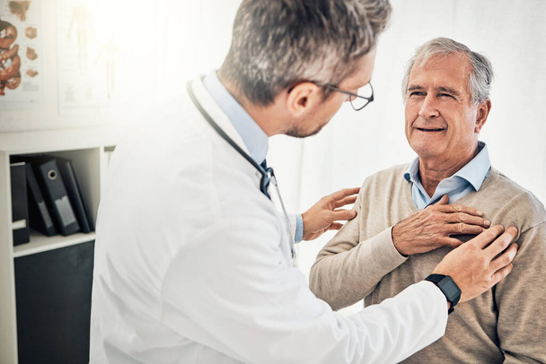 Patients appreciate his gentle bedside manner. a doctor checking his mature patients heart during a consultation in a medical center - Foto, afbeelding