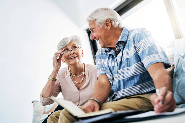Thats all our debt paid off. a senior couple going through their paperwork together at home - Foto, Imagem