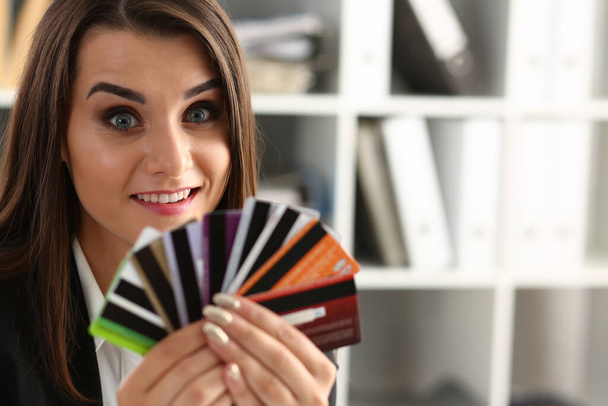 Portrait of young beautiful woman holding bank plastic credit cards. Choice of banking services and approved loan - Foto, imagen