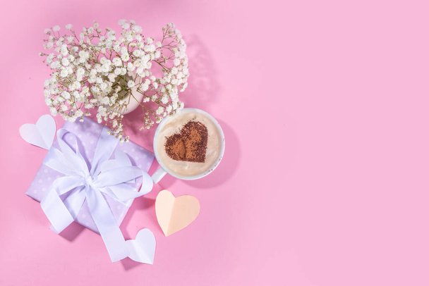 Moederdag pastelkleurige roze flatlay met geschenken, hartversierde koffiebeker, bloemen, notitie inscriptie Happy Mothers Day. Moeders internationale vakantie wenskaart achtergrond bovenaanzicht kopieerruimte - Foto, afbeelding