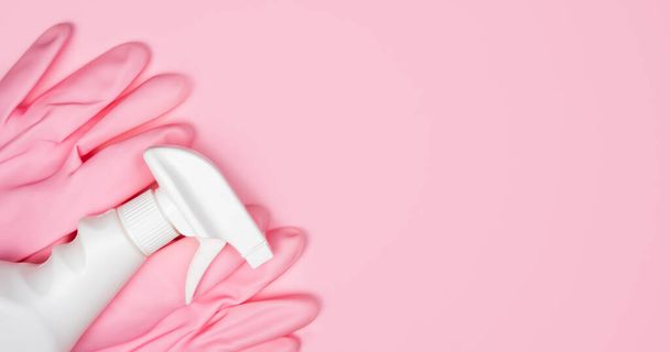 Pink rubber gloves and spray cleaner on a pink background. Flatlay. Banner. Close-up. Top view. Place for text. - Фото, изображение
