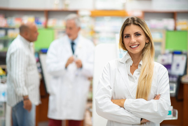 Portrait of a smiling young pharmacist in a pharmacy - Foto, Bild