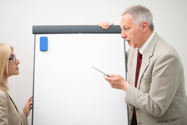 Businessman showing data on an empty whiteboard during a meeting - Photo, Image