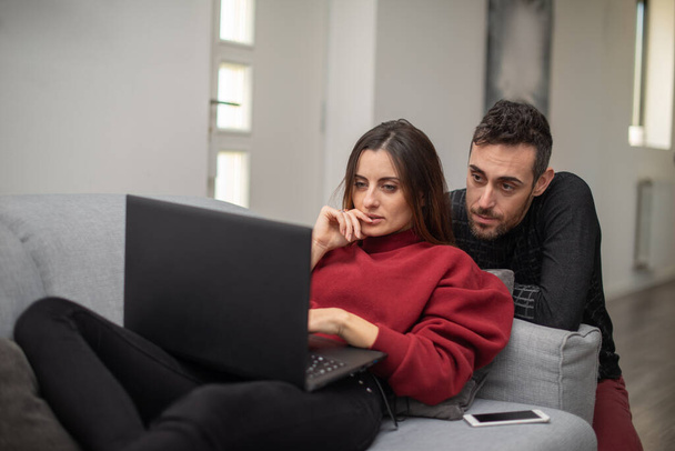 Portrait of a couple using a laptop computer in their house - Foto, imagen