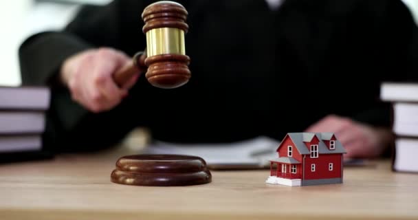 Small toy house standing on judge table closeup 4k movie slow motion. Division of property in divorce concept - Footage, Video