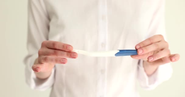 Mujer sosteniendo prueba de embarazo en las manos primer plano película 4k cámara lenta. Concepto de planificación del embarazo - Metraje, vídeo