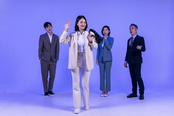 Asian Korean senior, middle aged and young male and female colleagues models in business attire, neon purple studio background, getting off work first concept - Photo, image