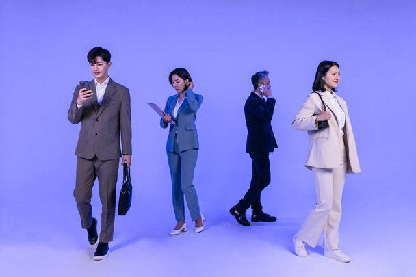 Asian Korean senior, middle aged and young male and female colleagues models in business attire, neon purple studio background, go separate ways concept - Photo, Image