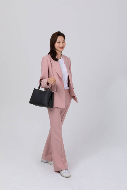 business concept korean young woman, holding a handbag. studio shot - Photo, Image