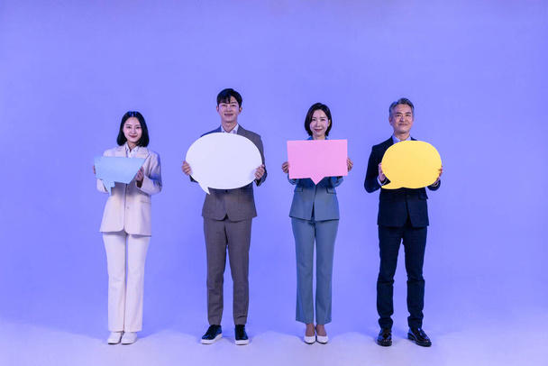Asian Korean senior, middle aged and young male and female colleagues models in business attire, neon purple studio background, holding panel concept - Foto, imagen