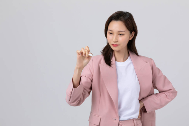 business concept korean young woman, holding a pen. studio shot - Foto, Imagem