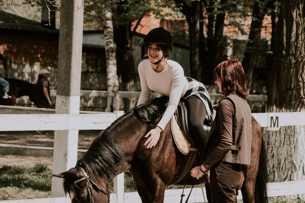Instruktorka ucząca dziewczynę jeździć na koniu. Żeński jeździec ćwiczący na koniu ucząc się jeździeckiego sportu. Koncepcja aktywnego stylu życia i aktywności rekreacyjnej - Zdjęcie, obraz
