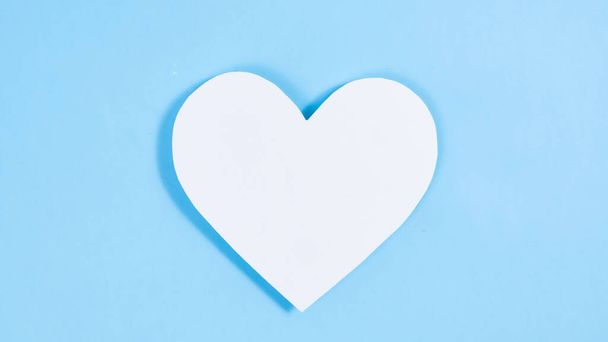 One big paper heart on blue background.  Symbol of love.  Template for design and text. Copy space. Flat Lay. - Fotografie, Obrázek