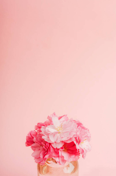 Букет з рожевих квітів сакури на рожевому тлі. Вітальна листівка, святковий фон. Копіювати простір
. - Фото, зображення