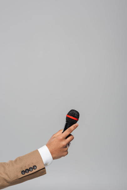 Viljelty näkymä käsi tapahtuman isäntä ruskea takki tilalla langaton mikrofoni suorituskyvyn aikana eristetty harmaa kopioi tilaa  - Valokuva, kuva