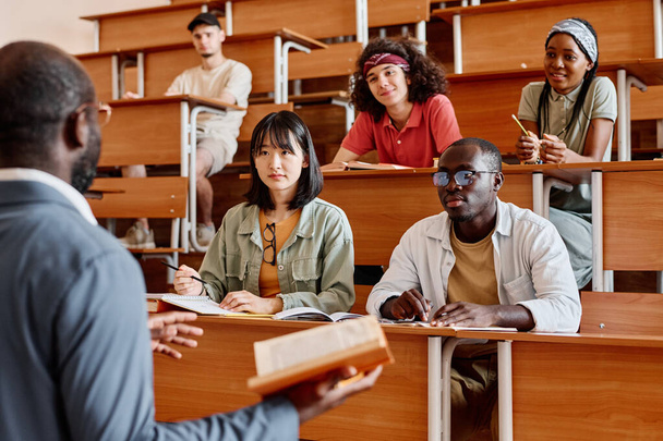 Studenten luisteren naar docent tijdens college aan de universiteit - Foto, afbeelding
