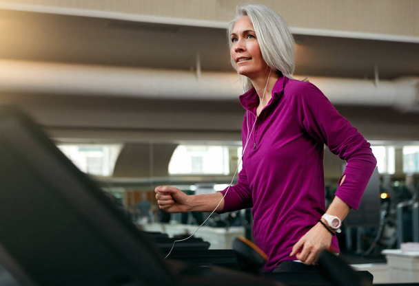 A tornaórát szívdobogtató futással fejezte be. egy érett nő gyakorol egy futópadon az edzőteremben - Fotó, kép