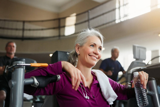 It is not about age but about attitude. Portrait of a happy senior woman having a rest during her workout at the gym - Foto, Imagen