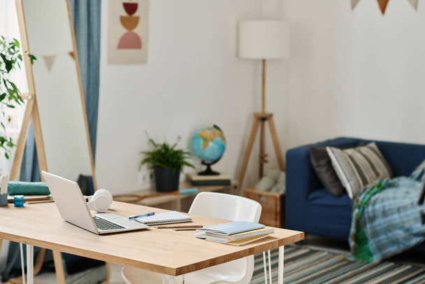 Horizontální obraz stolu s notebookem pro online studium stojící v místnosti pro teenagery - Fotografie, Obrázek