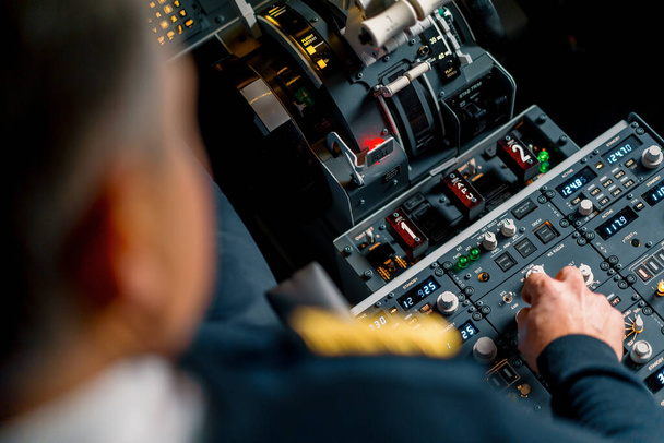 Il capitano preme i pulsanti sul pannello di controllo per avviare il motore di volo aereo Up close flight simulator - Foto, immagini