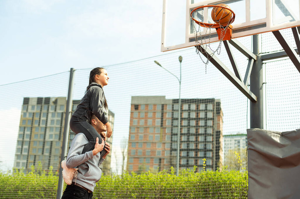 Счастливый отец и дочь-подросток на баскетбольной площадке - Фото, изображение